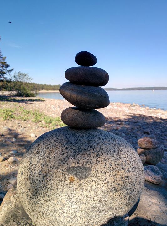 A cairn of round stones on a granite boulder