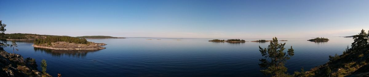 Panorama of a calm northern lake with low rocky islands