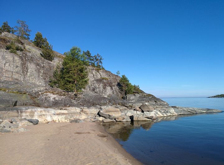 A quiet bay below a rocky slope