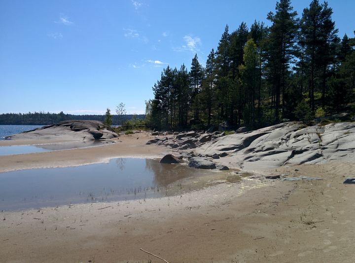 A sandy cove between smooth granite rocks
